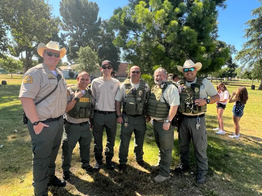 Reserve deputies in uniform standing together in a park
