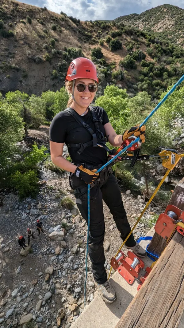 A rescuer rappelling from a bridge