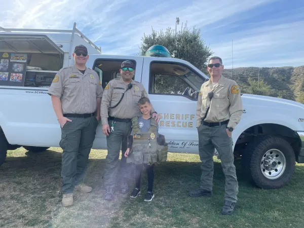 Deputies with a young visitor beside the rescue truck