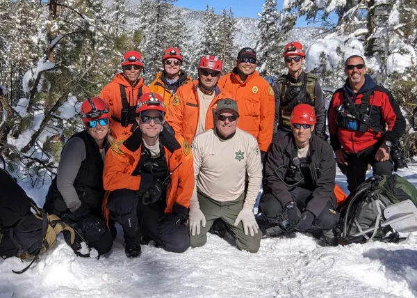 Team members kneeling together in deep snow