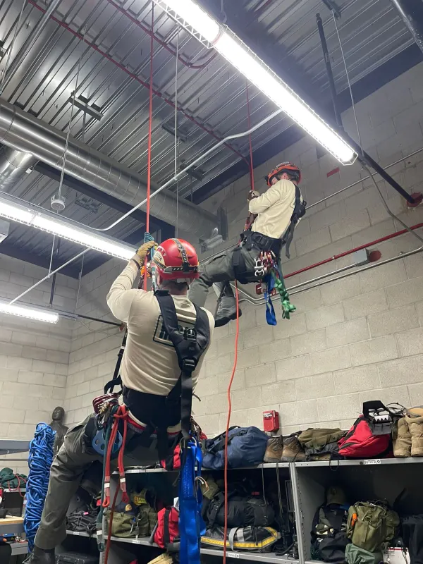 Members practicing rope ascents in the station training room
